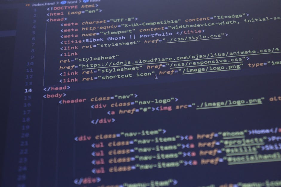 A close-up of a computer monitor displaying a code editor with colorful syntax highlighting. The screen shows lines of HTML and JavaScript code in red, blue, green, and yellow on a dark background. Th